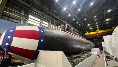US Navy submarine with American flag decoration in shipyard.
