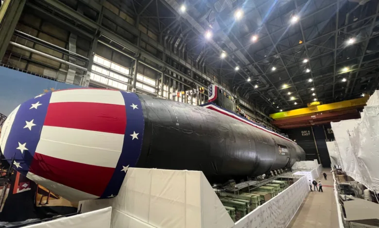 US Navy submarine with American flag decoration in shipyard.