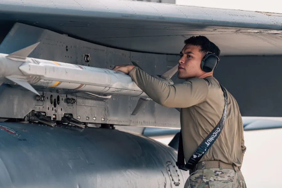 Airman inspects missile on fighter jet wing