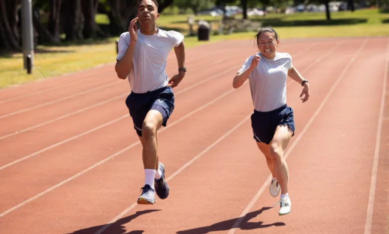 Two athletes, a man and a woman, run on a track during a race.