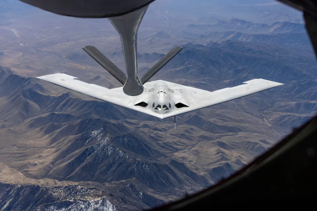 B-2 Spirit stealth bomber refuels mid-air over mountainous terrain