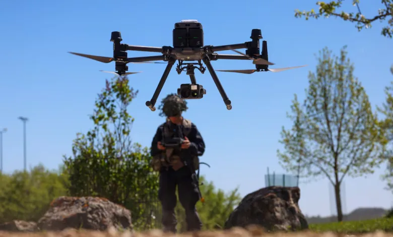 Drone operator controlling a DJI Matrice 300 RTK drone outdoors.