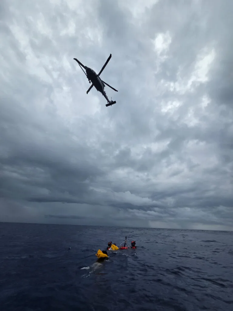 Helicopter rescues survivors from rough seas after plane crash.