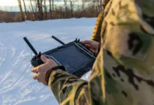 Military personnel operating a drone in snowy terrain