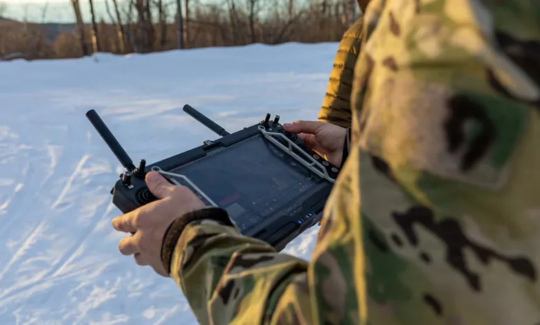 Military personnel operating a drone in snowy terrain
