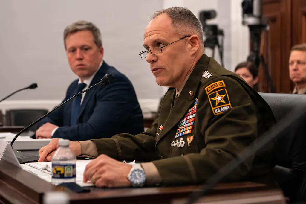 US Army Ranger addresses a committee, wearing a uniform with many medals.