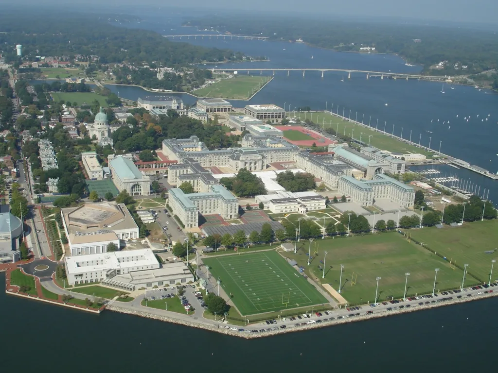 Aerial view of U.S. Naval Academy campus with buildings, sports fields, and water