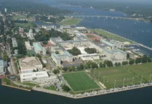 Aerial view of U.S. Naval Academy campus with buildings, sports fields, and water