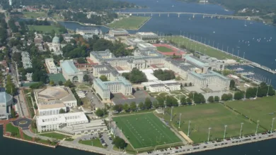 Aerial view of U.S. Naval Academy campus with buildings, sports fields, and water